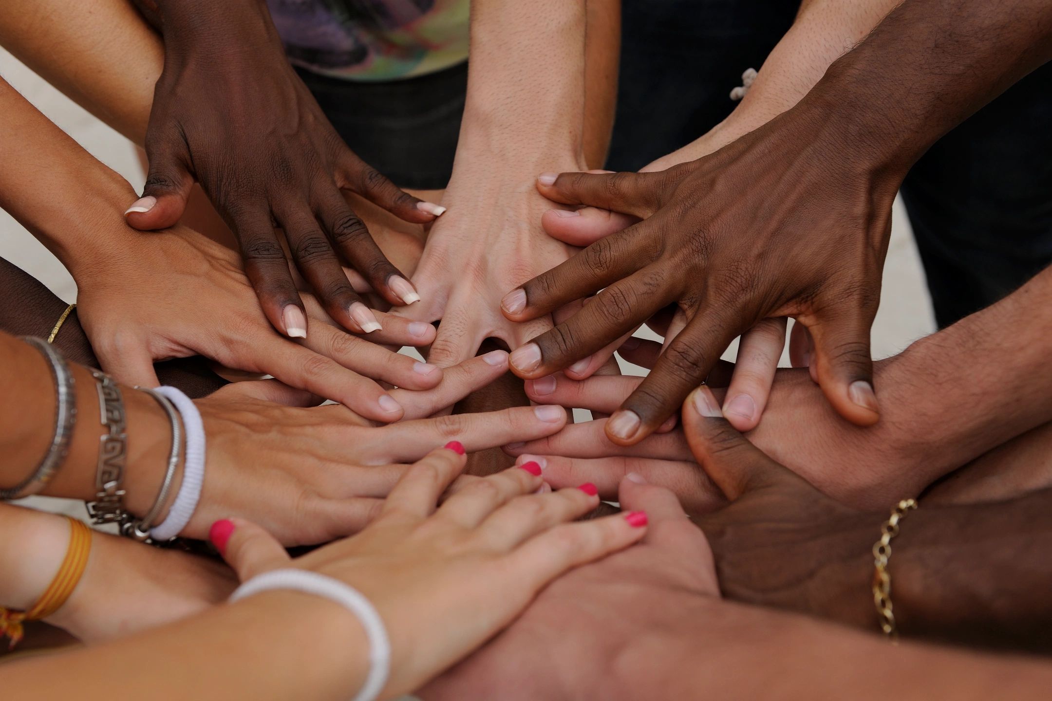 Diverse hands stacked together symbolizing unity