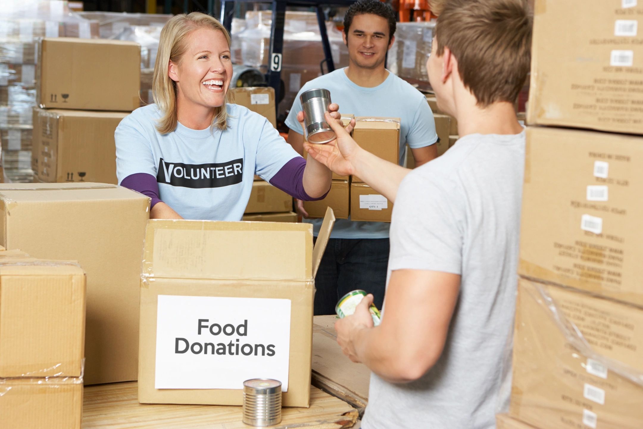 Volunteer handing food donations at a warehouse